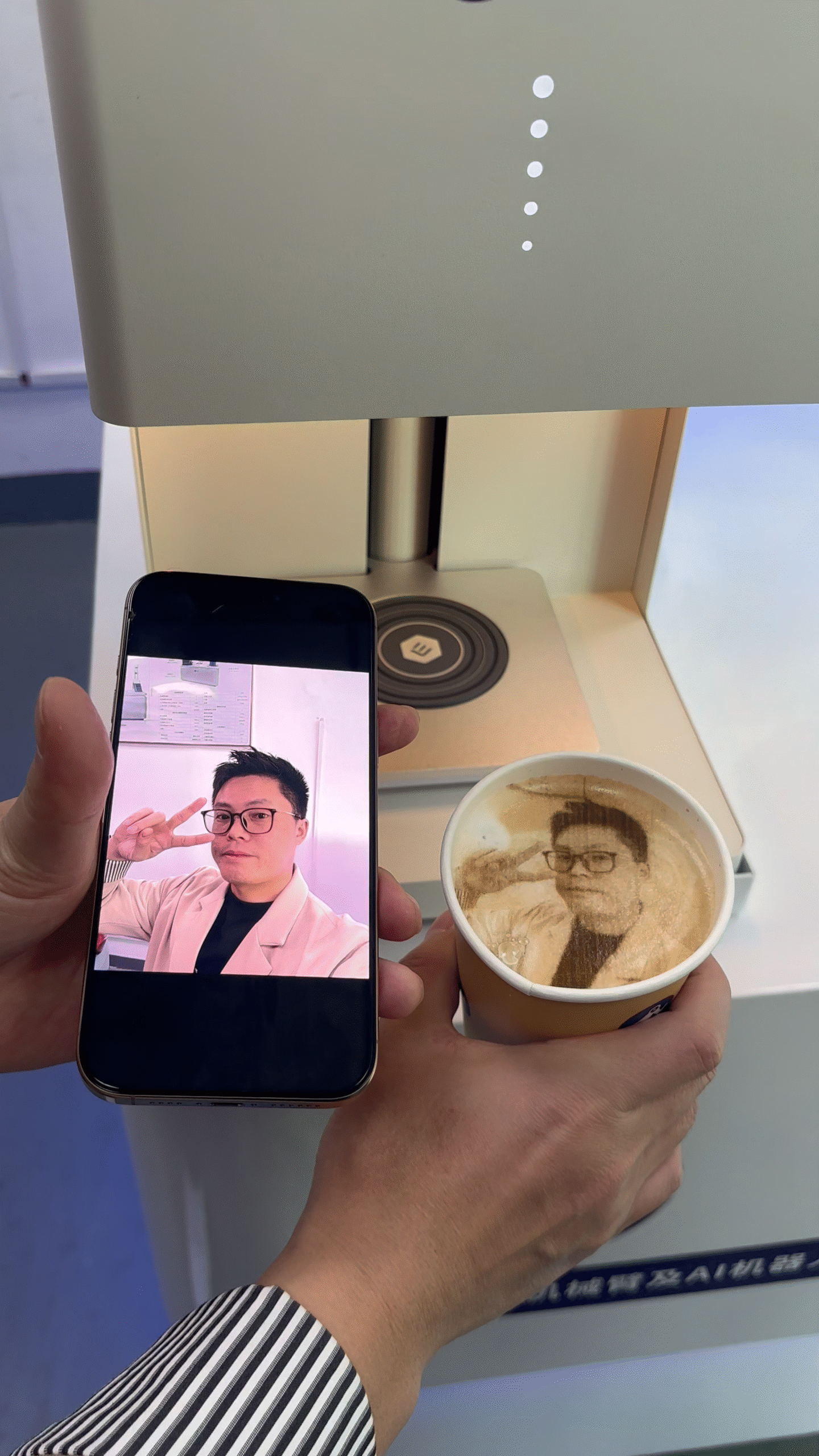 User comparing their selfie with printed latte art from Nova coffee robot
